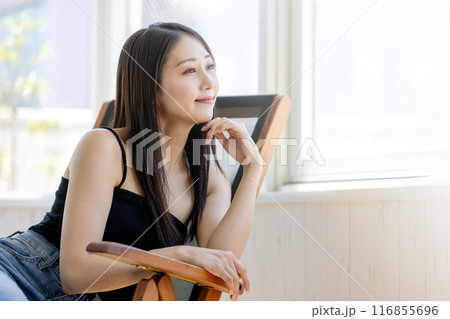 窓べで椅子に座る若い女性 窓べで椅子に座る若い女性 116855696