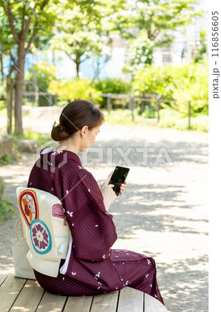 木陰に座りスマホを扱う着物姿の外国人女性 木陰に座りスマホを扱う着物姿の外国人女性 116856605
