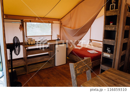 Interior of cozy open glamping tent. Camping tent for outdoor summer holiday and vacation Interior of cozy open glamping tent. Camping tent for outdoor summer holiday and vacation 116859310