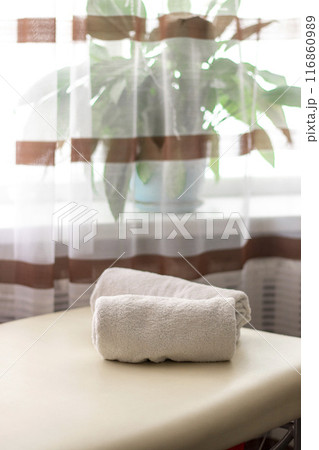 Close up shot of the white towels rolled in the massage couch. 116860989