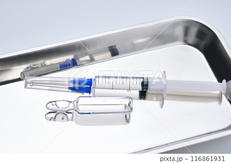 Syringes with needles and an ampoule in a stainless steel medical tray. Syringes with needles and an ampoule in a stainless steel medical tray. 116861931