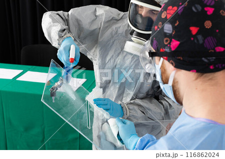 Two men work at polling stations under heavy pressure to thoroughly disinfect. 116862024