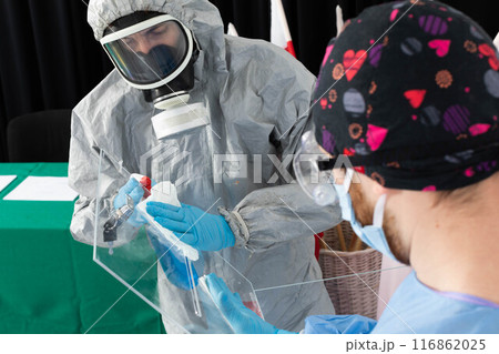 Two men work at polling stations under heavy pressure to thoroughly disinfect. 116862025