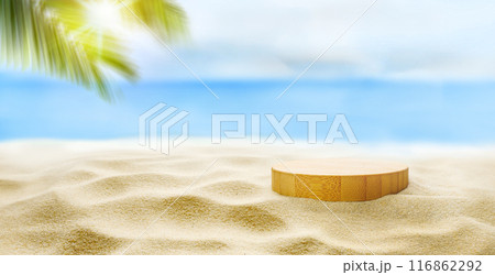 Tranquil tropical beach with round wooden pedestal on golden sand under palm tree with ocean in background 116862292