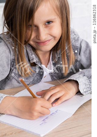 The student draws with crayons in the teddy bear school notebook as the subject of today's lesson. 116862318