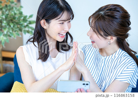 スマホで動画を楽しむ二人の女性 スマホで動画を楽しむ二人の女性 116863158