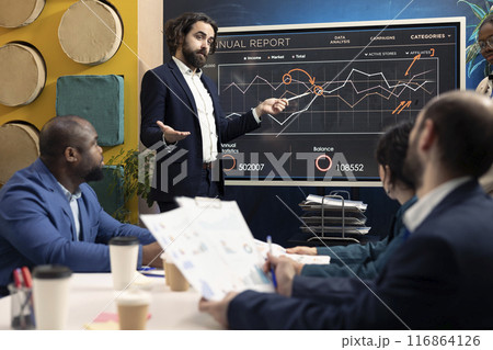 Chief operating officer presenting project goals and resource allocation during a meeting, creating successful pitch to present his ideas. Review performance indicators and marketing strategies. Chief operating officer presenting project goals and resource allocation during a meeting, creating successful pitch to present his ideas. Review performance indicators and marketing strategies. 116864126