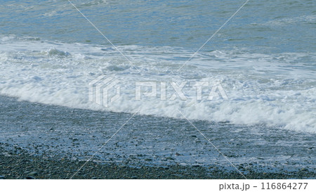 White Foam Wave Beaching On Sea Shore Pebbles. Pebble Beach Foam Sea Surf. Still. 116864277