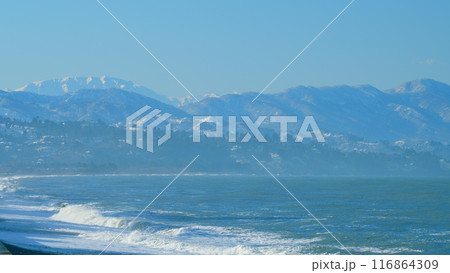 Pebble Beach Of The Black Sea With A Coastline. Surf On A Background Of The City. Real time. Pebble Beach Of The Black Sea With A Coastline. Surf On A Background Of The City. Real time. 116864309