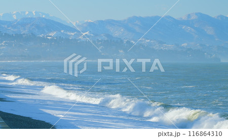 Foam Waves On The Beach. Beach Against The Mountains And The Sky On A Sunny Summer Morning. Real time. Foam Waves On The Beach. Beach Against The Mountains And The Sky On A Sunny Summer Morning. Real time. 116864310