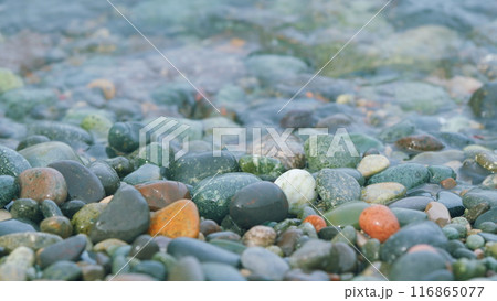 Sea Stones Are Visible Through Clear Water Of Waves. Pebbles On The Seashore. Close up. Sea Stones Are Visible Through Clear Water Of Waves. Pebbles On The Seashore. Close up. 116865077