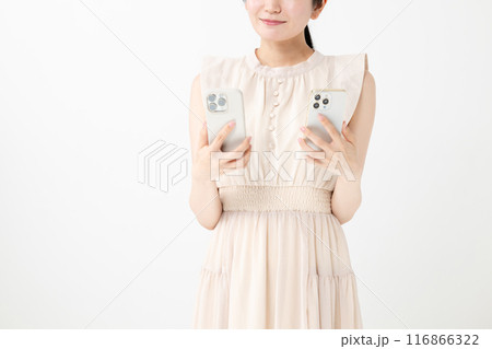 笑顔でスマホを2台持つ女性 116866322