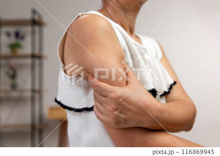 Middle aged woman worry squeezing excess fat of upperarms. 116869945