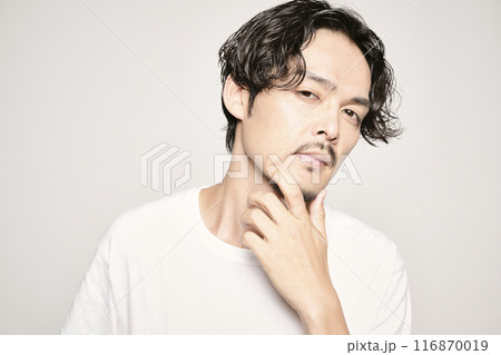 白バックで頬に手を当てる男性 116870019