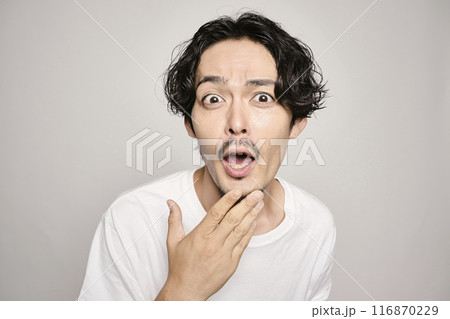 白バックで頬に手を当てる男性 116870229