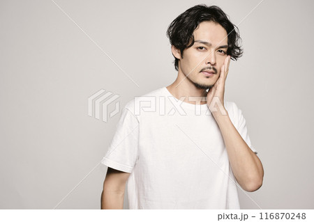 白バックで頬に手を当てる男性 116870248
