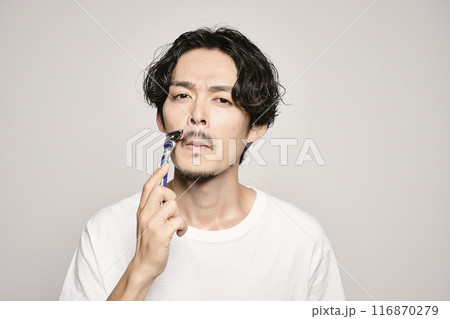 白バックでカミソリで髭剃りをする男性 116870279