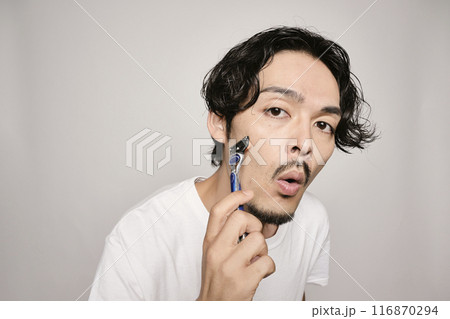 白バックでカミソリで髭剃りをする男性 116870294