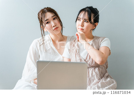 家で友達と一緒にノートパソコンを使う女性・友達・ママ友・仲間（悩む・考える・怒る・ストレス） 116871034