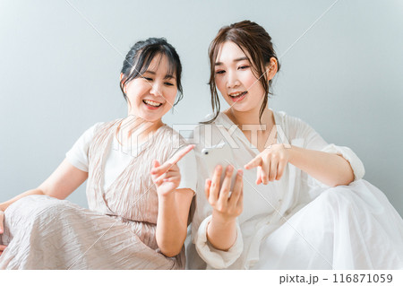 家で一緒にスマホを使う女性・友達・ママ友・仲間 家で一緒にスマホを使う女性・友達・ママ友・仲間 116871059