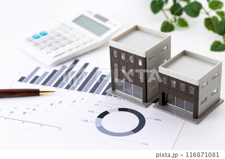 企業のオフィスビルとグラフと電卓 116871081