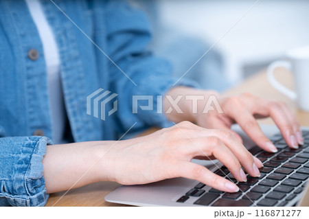キーボードでタイピングをするカジュアルな女性の手元【パーツカット】 キーボードでタイピングをするカジュアルな女性の手元【パーツカット】 116871277