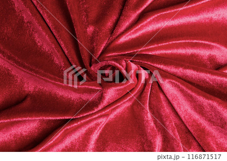 Textured background of deep red velvet fabric with folds. 116871517