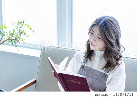 ソファーで読書をする若い女性 ソファーで読書をする若い女性 116871711