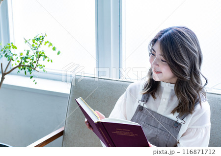 ソファーで読書をする若い女性 ソファーで読書をする若い女性 116871712