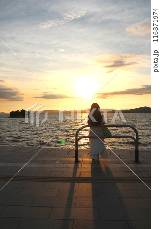 湖で落陽を楽しむ女性 116871974