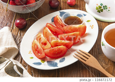 Sliced red tomato with brown sugar ginger dipping sauce  116872172