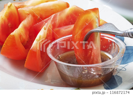 Sliced red tomato with brown sugar ginger dipping sauce  116872174