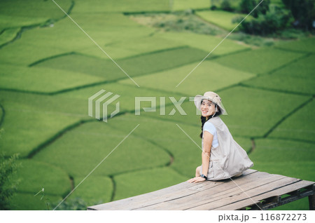 Happiness tourist woman visiting beautiful rice paddy field in Sapan village a small village nestled in a forested northern valley of pure air and pristine rivers in Nan province of Thailand. Happiness tourist woman visiting beautiful rice paddy field in Sapan village a small village nestled in a forested northern valley of pure air and pristine rivers in Nan province of Thailand. 116872273