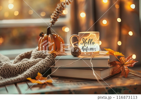lightbox with the text Hello Autumn, on top of books, autumn decorations and a coffee mug in the background lightbox with the text Hello Autumn, on top of books, autumn decorations and a coffee mug in the background 116873113