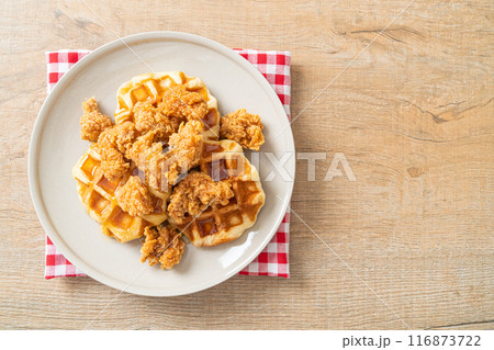 fried chicken waffle with honey or maple syrup fried chicken waffle with honey or maple syrup 116873722