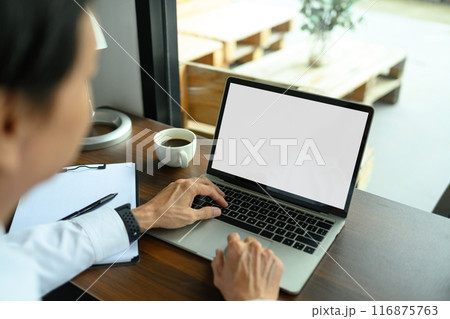 Over shoulder view of senior businessman using laptop on wooden table at coffee shop Over shoulder view of senior businessman using laptop on wooden table at coffee shop 116875763