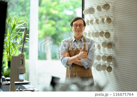 Portrait of middle aged man small business owner showing thumbs up and smiling confidently at his coffee shop Portrait of middle aged man small business owner showing thumbs up and smiling confidently at his coffee shop 116875764