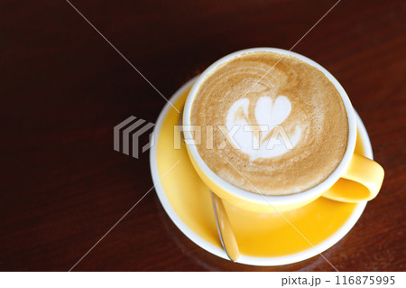 hot coffee cup latte art with spoon Serve ready to drink in cafe on wooden table coffee shop.  Leave copy space empty to write the side text. soft focus. 116875995