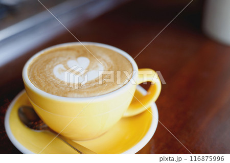 hot coffee cup latte art with spoon Serve ready to drink in cafe on wooden table coffee shop.  Leave copy space empty to write the side text. soft focus. 116875996