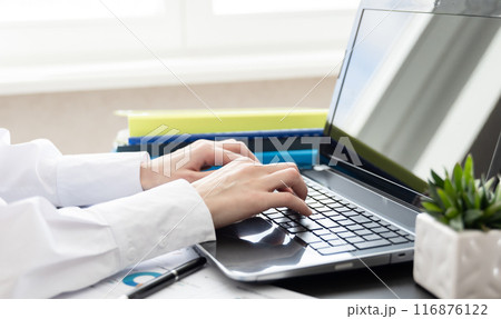 Woman working at home or office. Hand on keyboard. Close up. Workplace 116876122