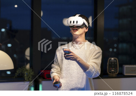VRゴーグルをしてハンドコントローラーを持った若い男性 116878524