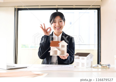 住宅模型を持ちOKをするビジネスウーマン 116879527