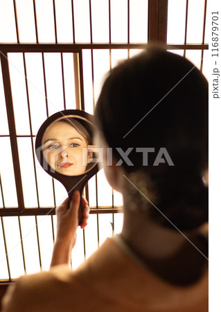 障子の前で手鏡を見る着物姿の外国人女性 116879701