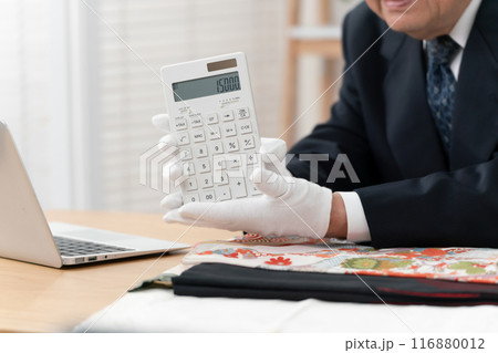 査定をする男性　リサイクル　計算機　手元 116880012