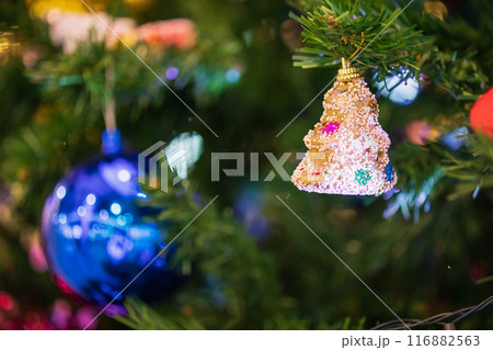 Decorated Christmas baubles on fir tree New Year holidays background 116882563