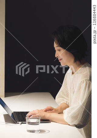 夜、パソコンに向かって作業するミドル女性 夜、パソコンに向かって作業するミドル女性 116884443
