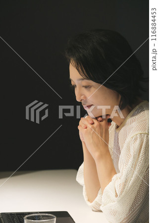 夜、パソコンに向かって作業するミドル女性 116884453