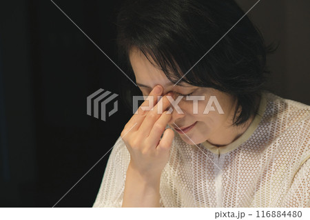 夜、パソコンに向かって作業するミドル女性 116884480