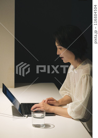 夜、パソコンに向かって作業するミドル女性 夜、パソコンに向かって作業するミドル女性 116884504