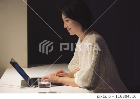 夜、パソコンに向かって作業するミドル女性 116884510